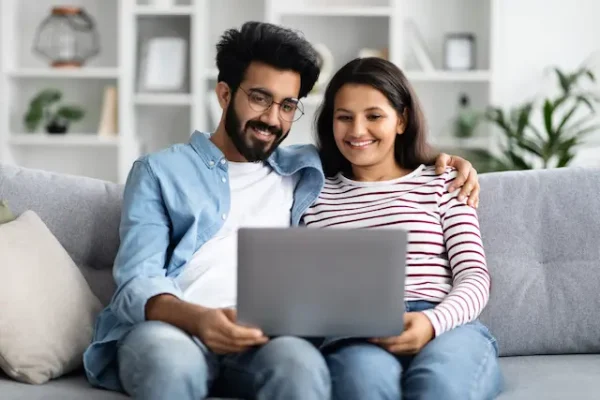 sweet-hindu-couple-watching-movie-on-laptop-at-hom-2023-11-27-05-02-47-utc-scaled